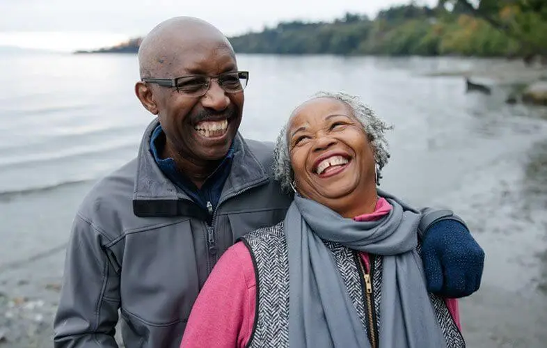 A happy couple hiking near a lake.