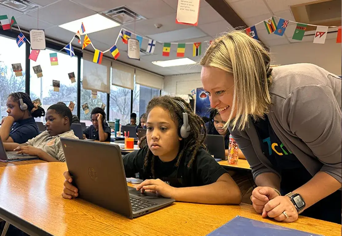 A teacher assisting a student in a classroom